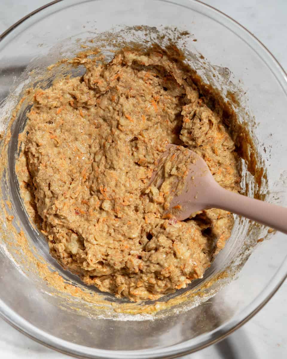 Wet and dry muffin ingredients whisked together in a bowl.