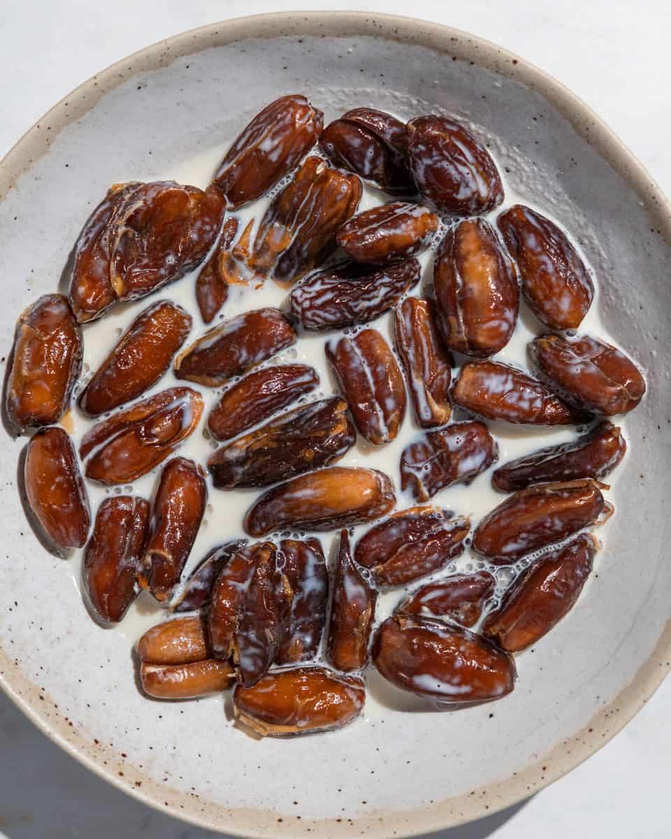 Dates soaked in milk in a bowl.