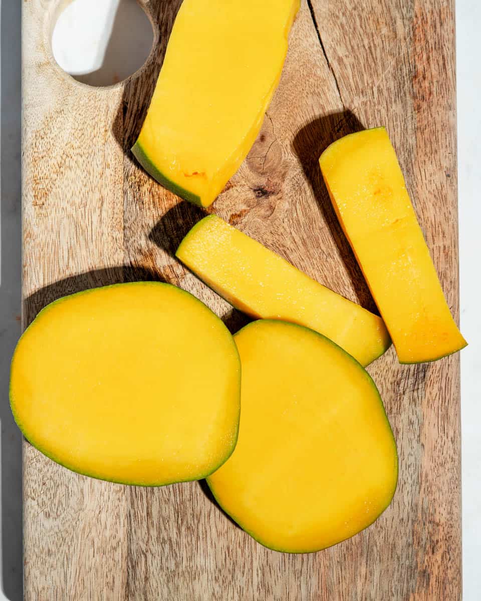 Mango cut open on a cutting board.