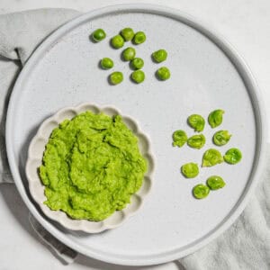 Pea puree, mashed peas and whole cooked peas on a plate.