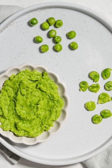 Pea puree, mashed peas and whole cooked peas on a plate.