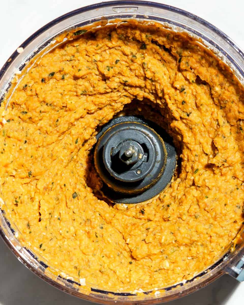 nugget mixture blended in a food processor, showing a thick orange mixture made from sweet potato and seasonings.