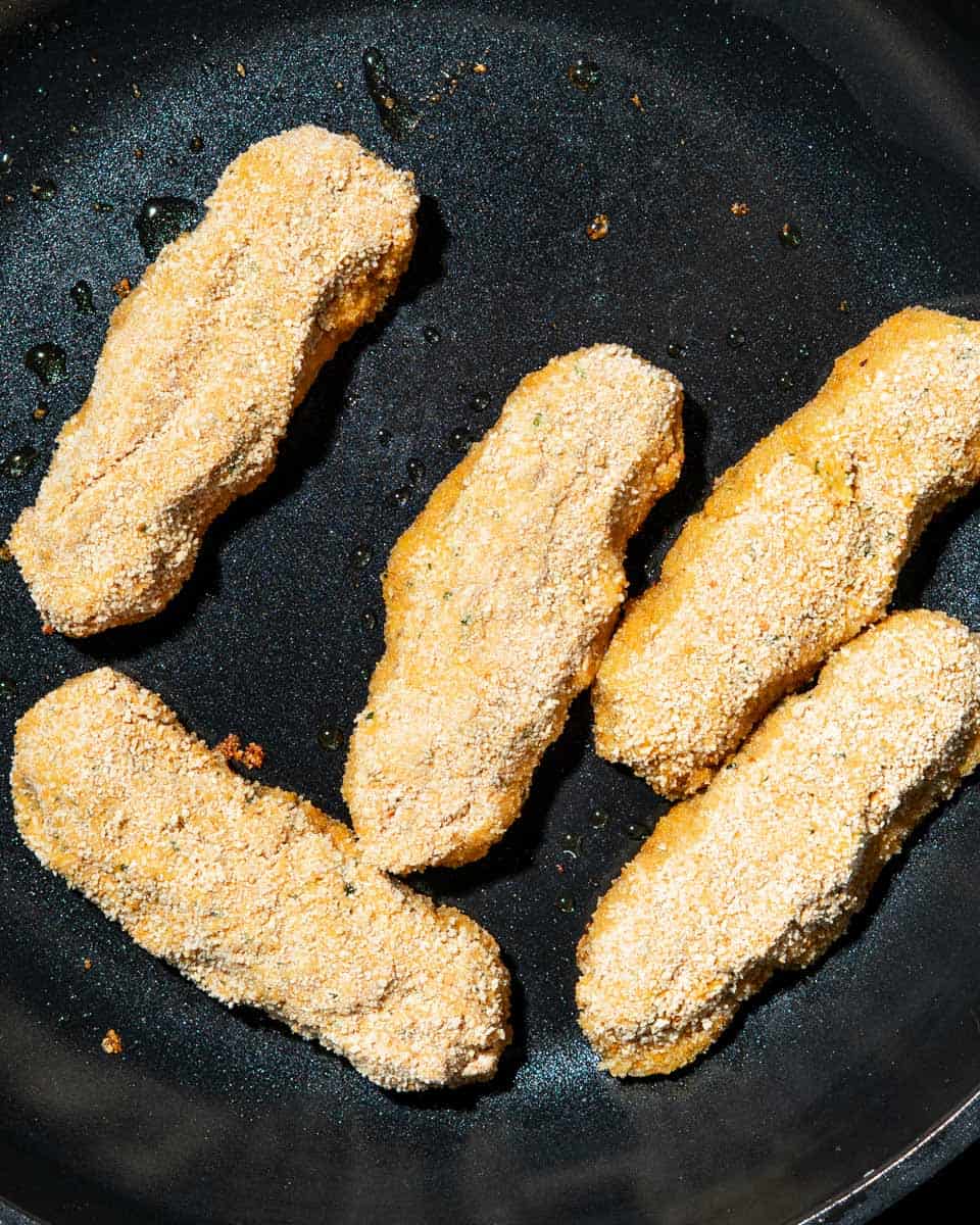 Nuggets being fried in a pan.